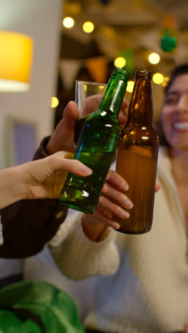 Vertical-Video-Of-Group-Of-Friends-At-Home-Or-In-Bar-Celebrating-At-St-Patrick's-Day-Party-Drinking-Alcohol-And-Doing-Cheers-Together-3